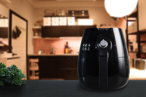 Air fryer on a kitchen counter with cooked food