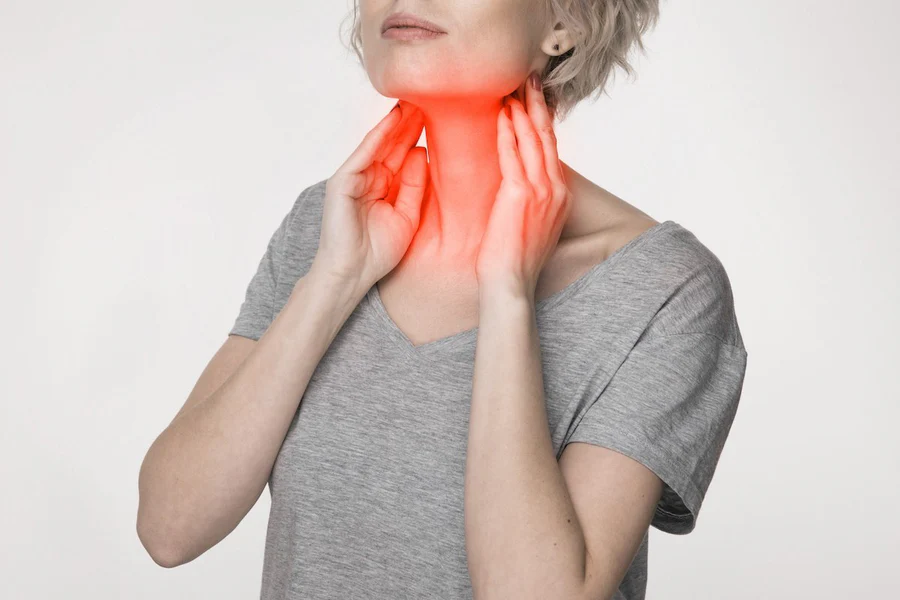 Woman using red light therapy on face and neck